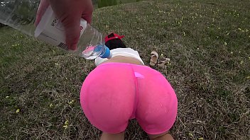 Lesbian with a bottle fucks girlfriend in hairy pussy. Wet juicy booty doggystyle in shorts outdoors.